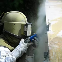 Worker Sandblasting Wall